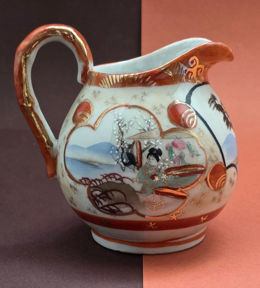 Japanese Kutani porcelain milk jug – front view showing geisha panel with blossoming plum and mountain lake